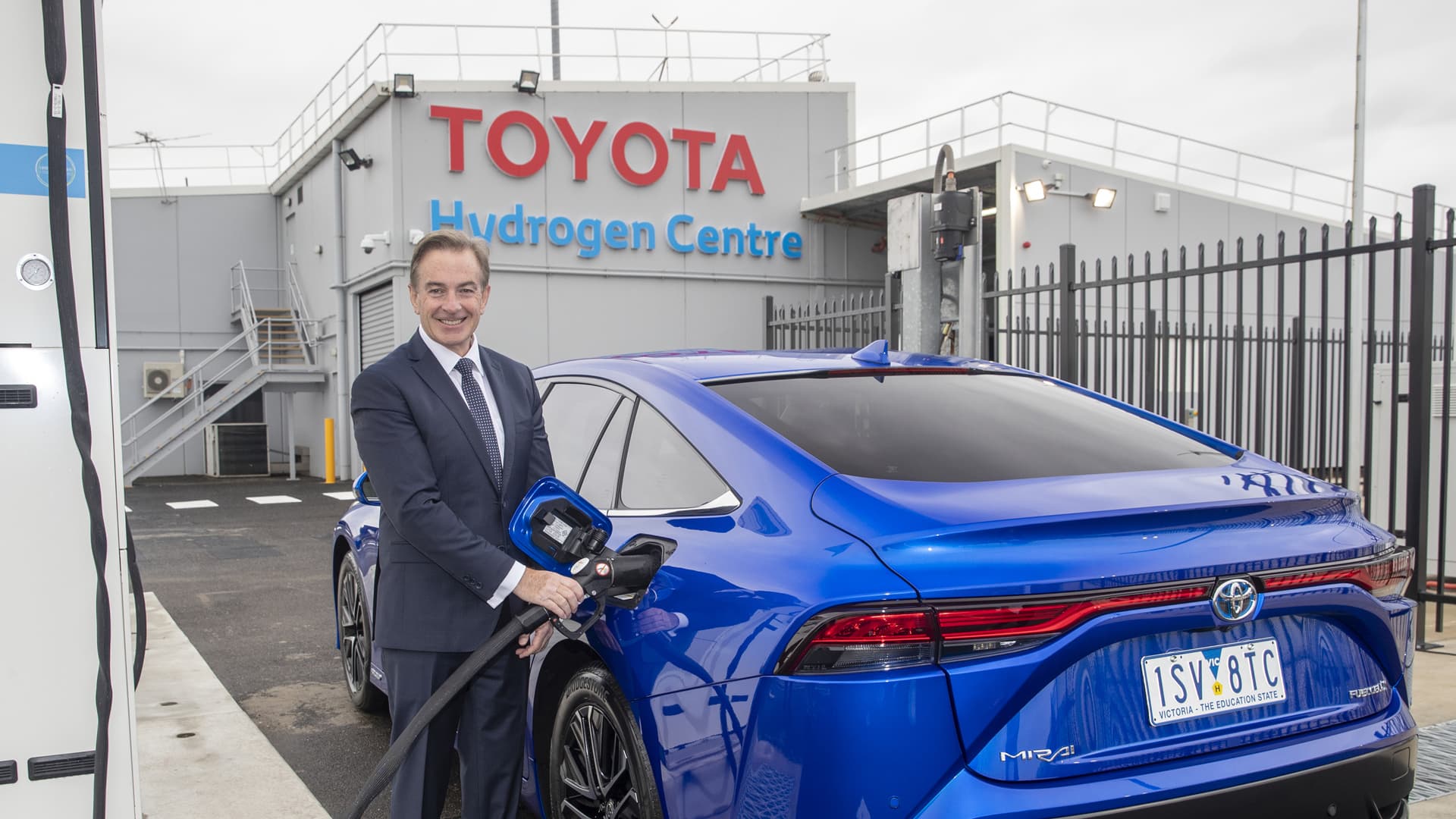 Matthew Callachor, the President and CEO of Toyota Australia, refuels a blue Toyota Mirai at a hydrogen pump, at the Toyota Hydrogen Centre in Altona, Victoria.