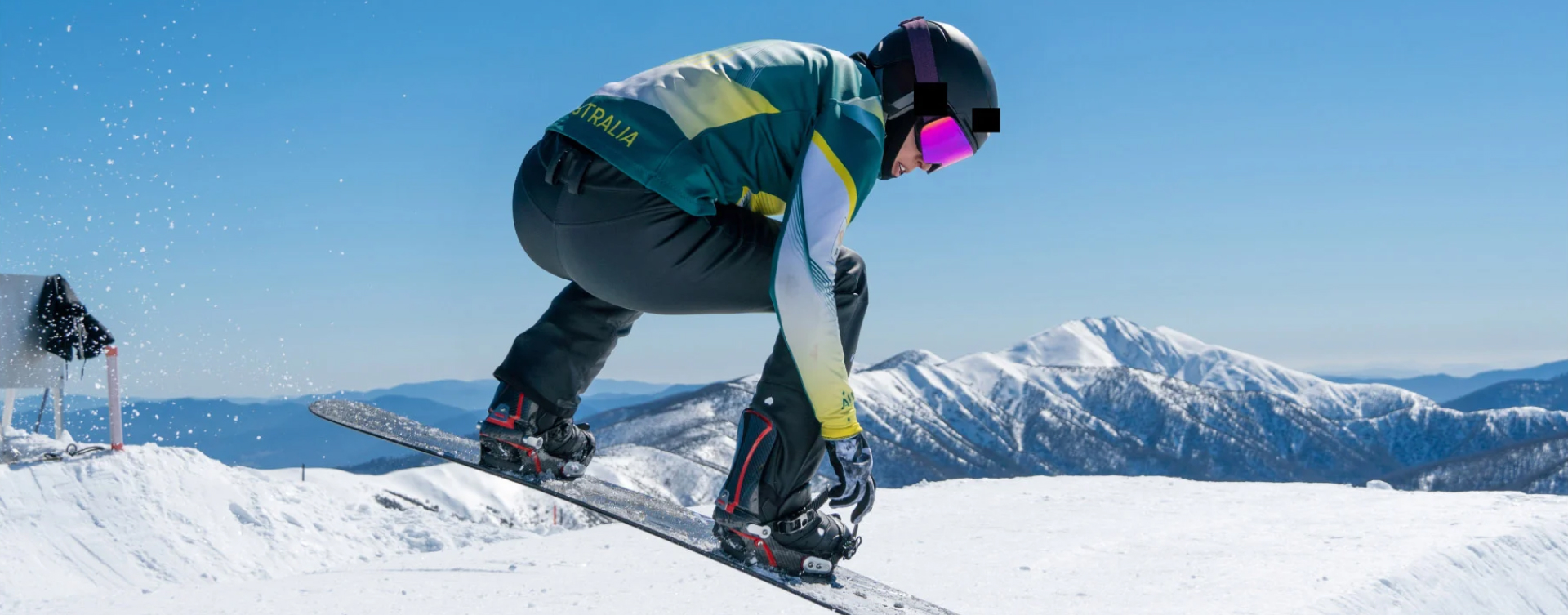 Australian Olympian snowboarder Belle Brockhoff, in a mid-air jump while snowboarding down a mountain.