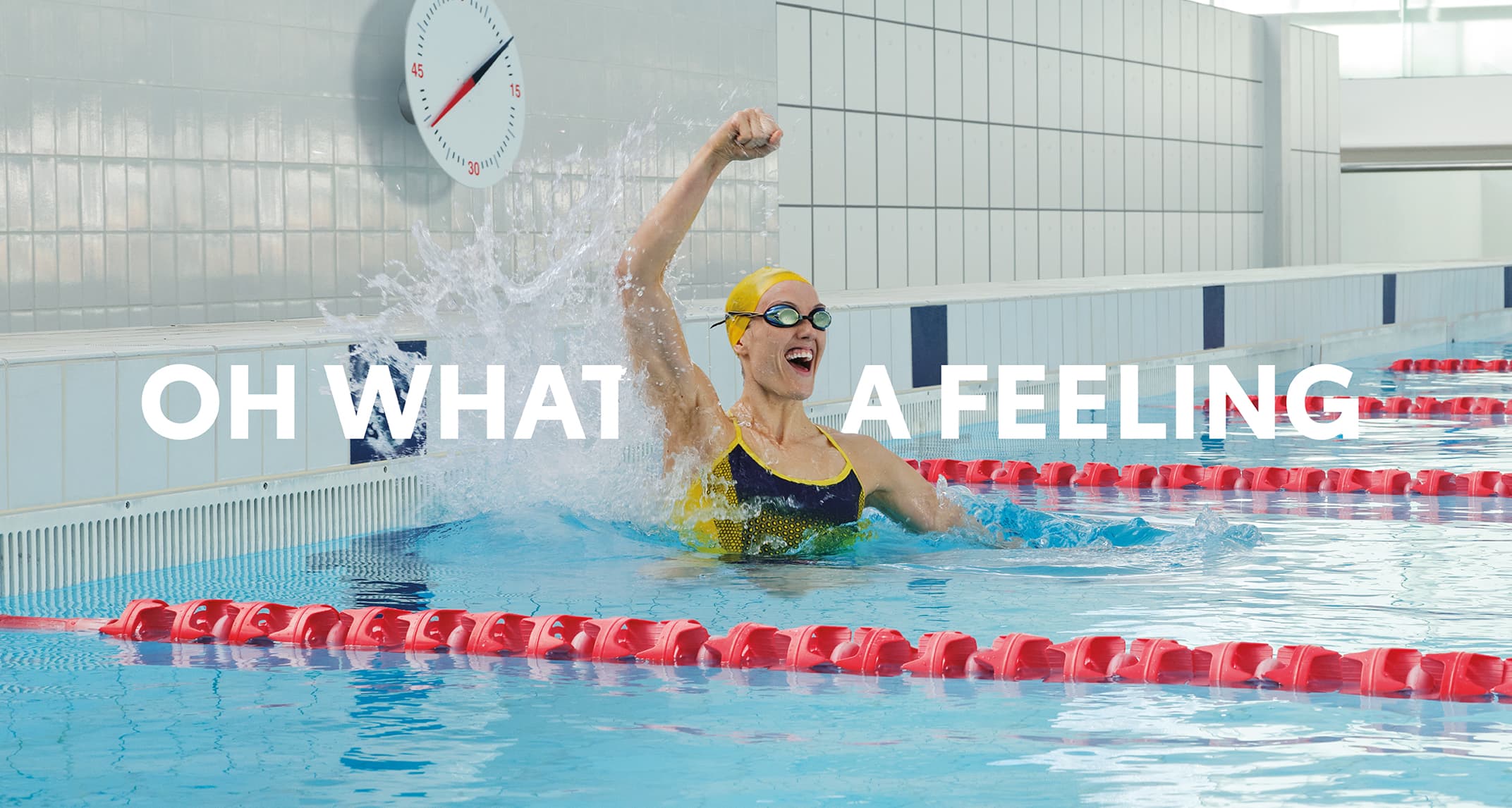 Australian Paralympian swimmer Ellie Cole in a sports swimming pool, cheering excitedly with her fist in the air. ‘OH WHAT A FEELING’ is superimposed into the image.