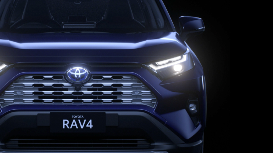 The front view of a black Toyota RAV4 in a dark atmosphere, headlights shining in the dark.