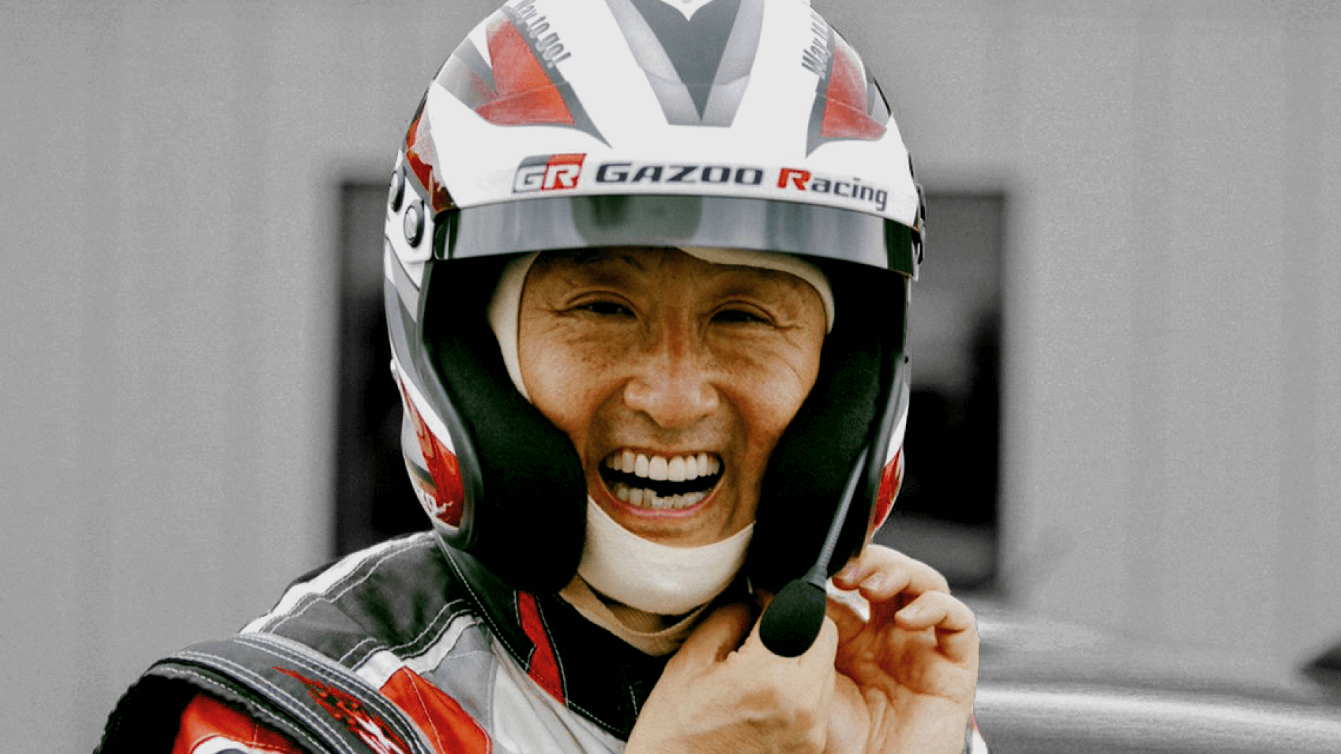 Morizo, aka former Toyota President Akio Toyoda, smiling wearing a TOYOTA GAZOO Racing helmet.