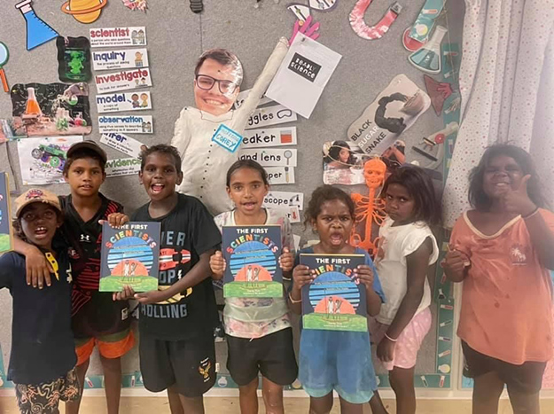 A group of First Nations children stand together, proudly presenting and celebrating their certificates, earned as a part of the DeadlyScience program.