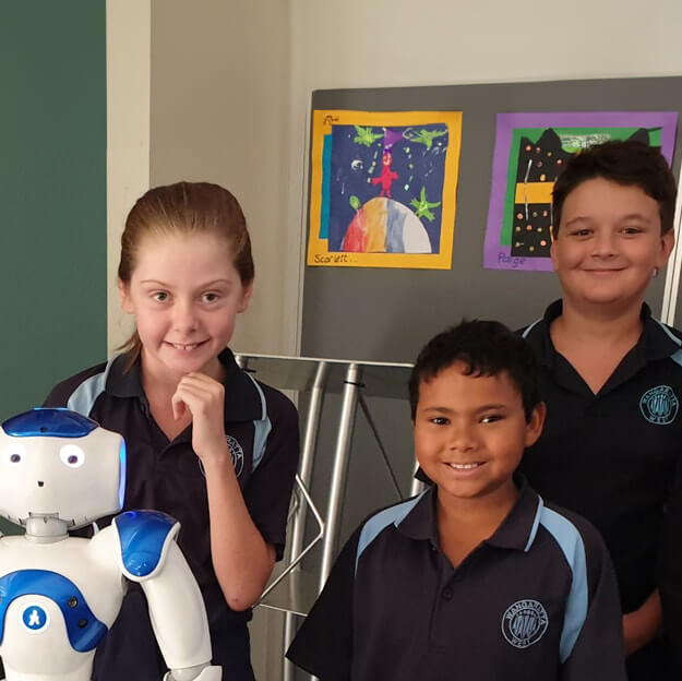 Three young Wangaratta West Primary School students posed with a friendly-looking white and blue robot.