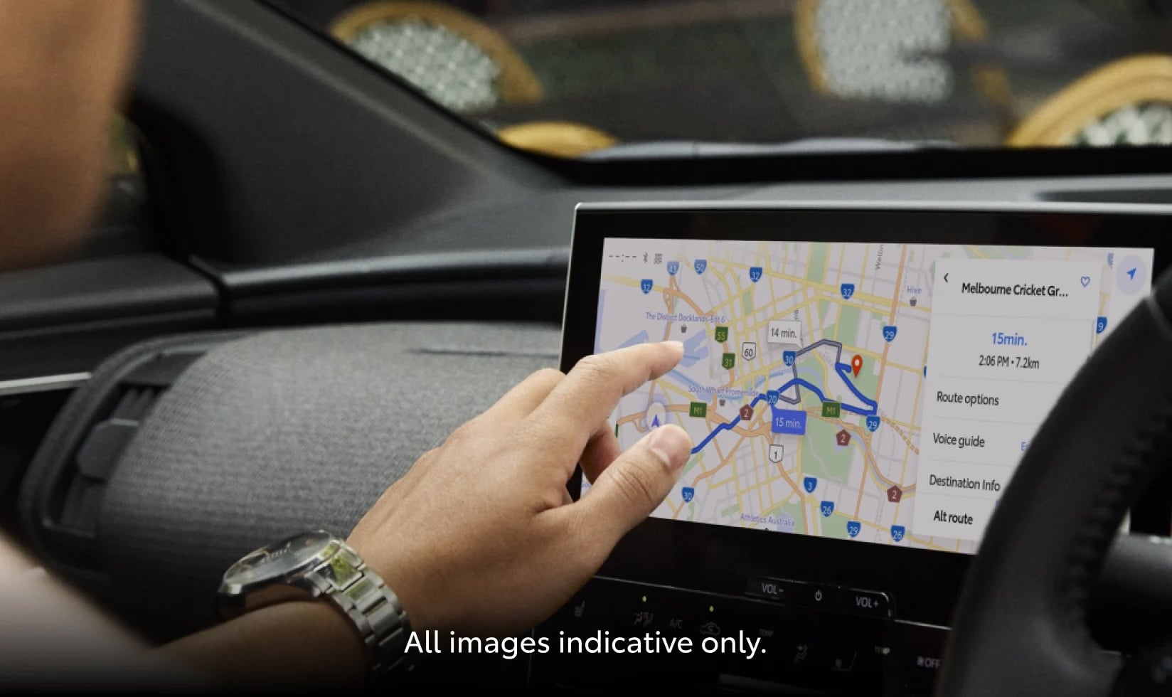 A person sitting in the driver's seat of a toyota using the multimedia touch screen, about to access the maps feature.
