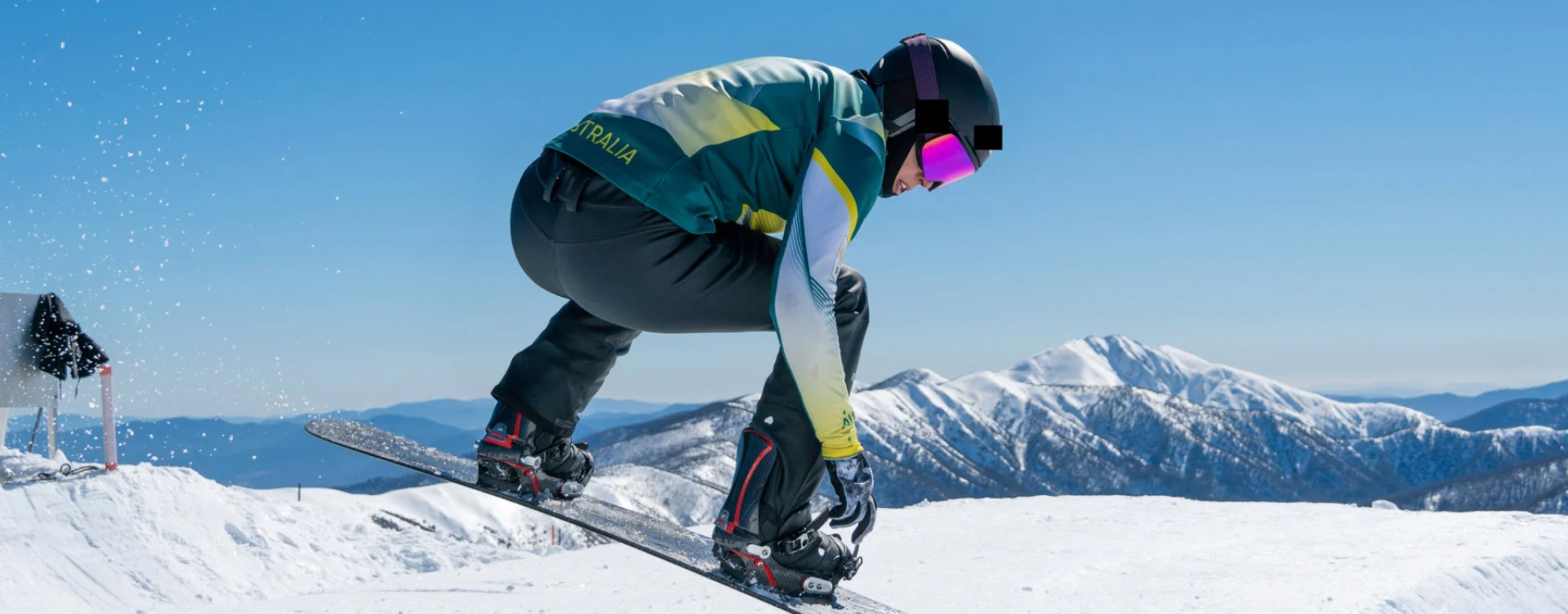 Australian Olympian snowboarder Belle Brockhoff, in a mid-air jump while snowboarding down a mountain.