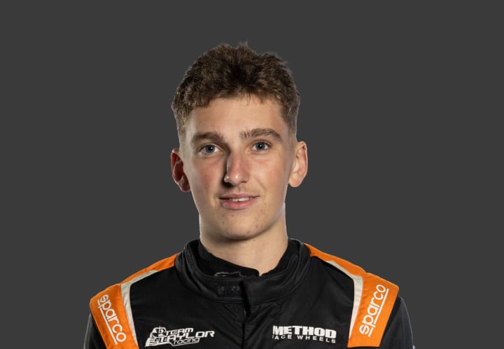 A headshot of professional T G R A driver Lincoln Taylor in a black, orange and white racing suit against a grey background.