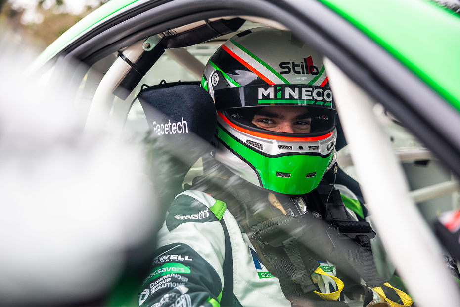 Professional racing driver Bradi Owen in green and black racing gear at the wheel of a Toyota G R 86.