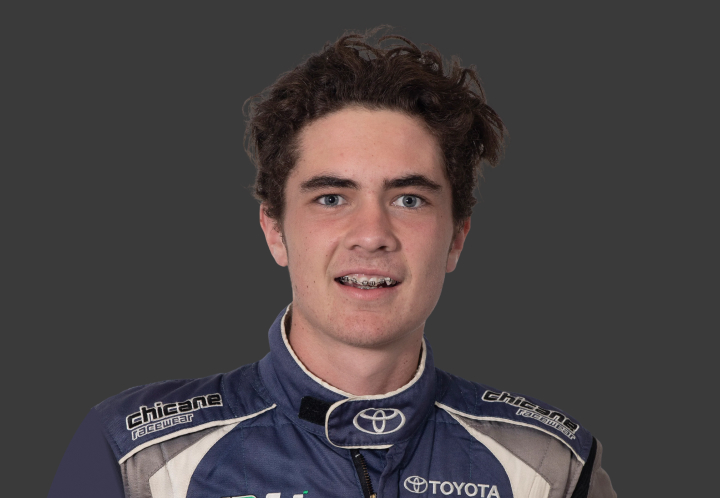 A headshot of professional T G R A driver Jaden Ransley in a blue, grey and white racing suit on a grey background.