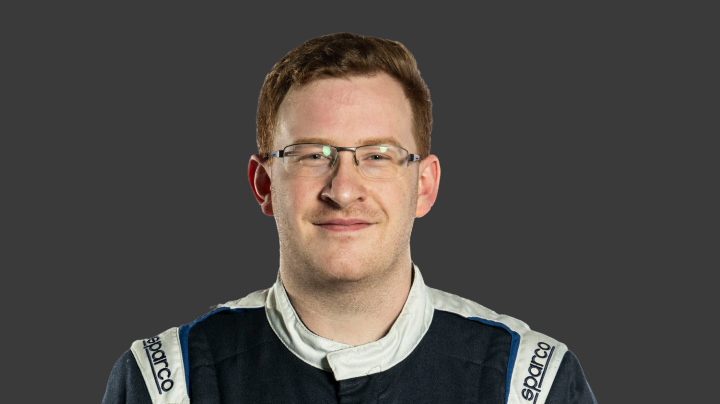 A headshot of professional T G R A driver Lachlan Gibbons on a grey background.