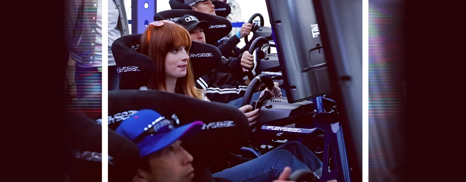 e-Motosports racer Emily Jones in the seat of a driving simulator, competing with other racers at an event.