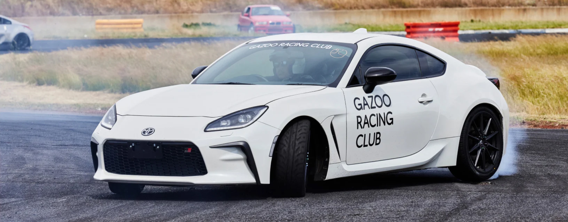 A White Liquid Toyota G R 86 with Gazoo Racing Club branding, burning rubber on the track at Calder Park Raceway.