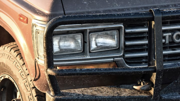 A shot of the dirty and dusty headlights of a 1996 LandCruiser model.