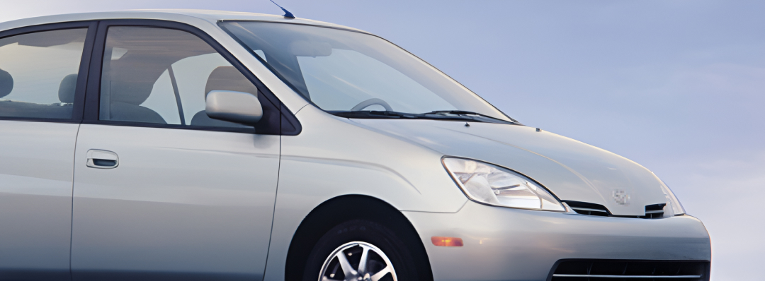 A silver Toyota Prius, a blue sky backdrop in the distance.