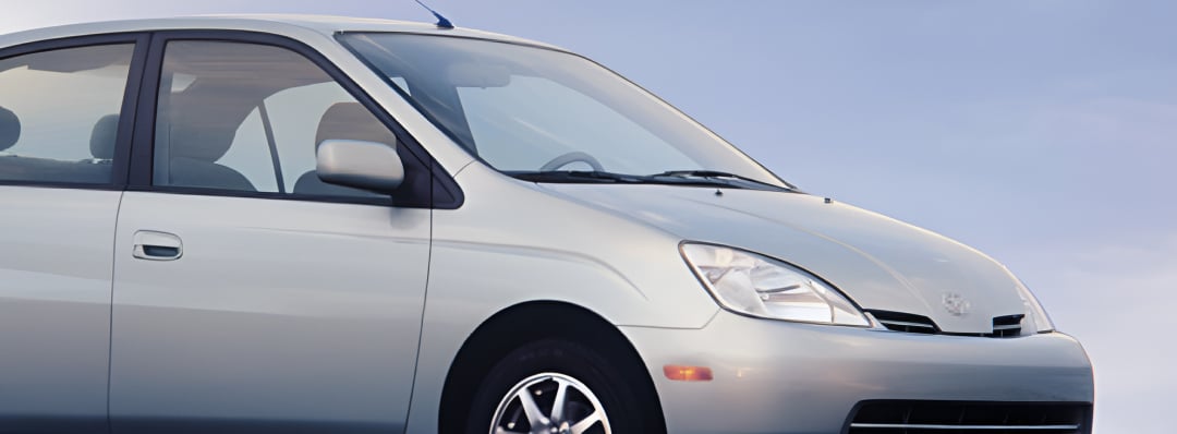 A silver Toyota Prius, a blue sky backdrop in the distance.