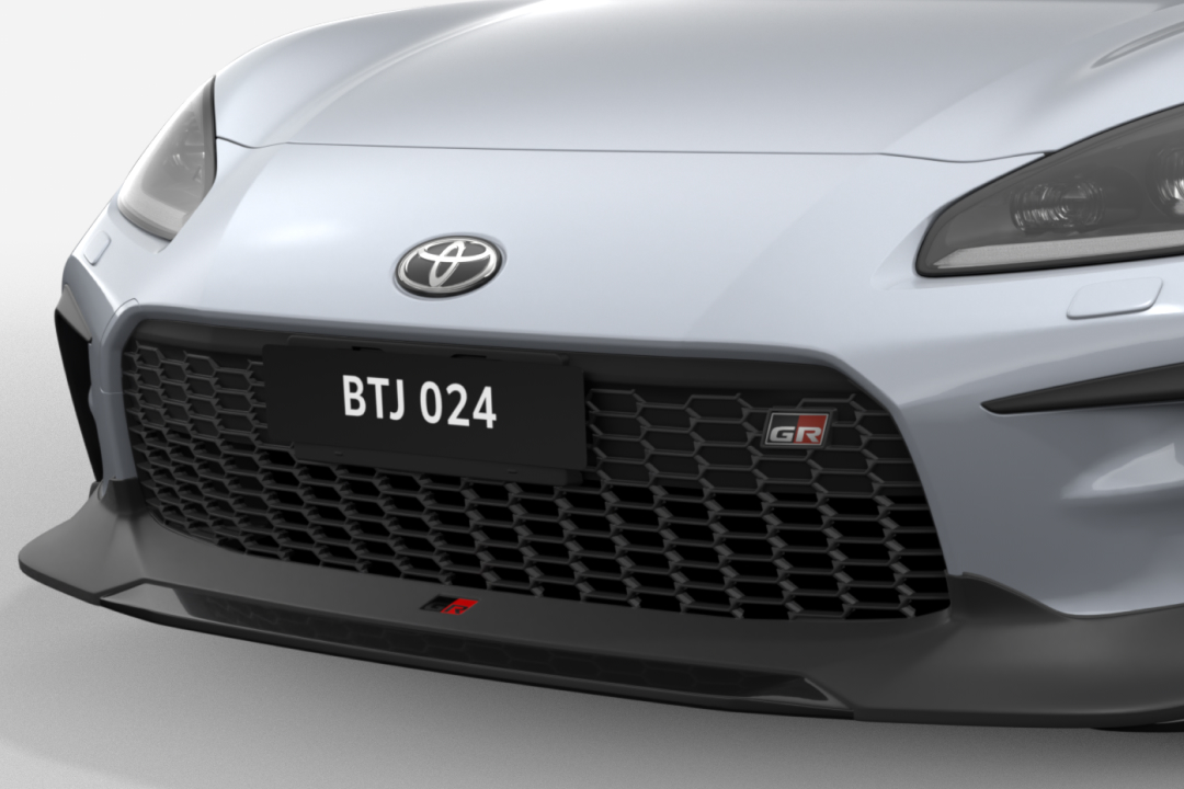A Toyota Genuine G R Front Spoiler attached to the front of a G R 86 in Ice Silver Metallic.
