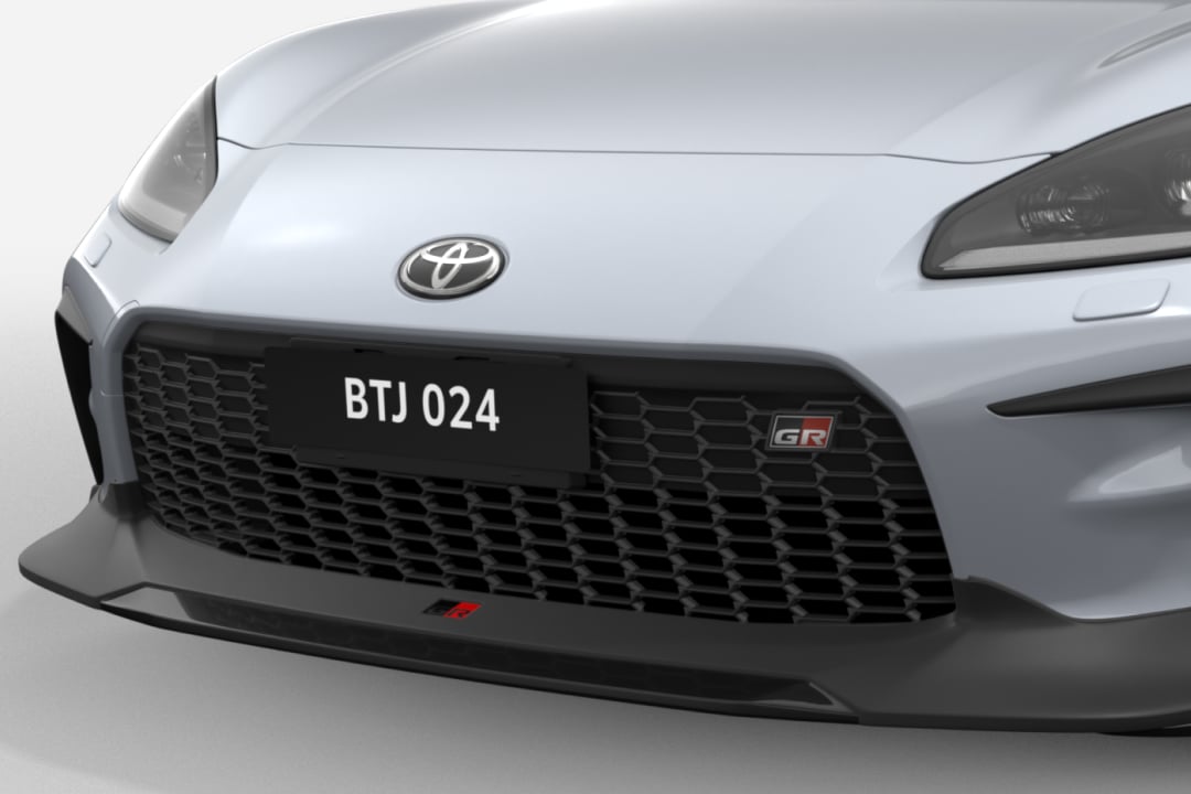 A Toyota Genuine G R Front Spoiler attached to the front of a G R 86 in Ice Silver Metallic.