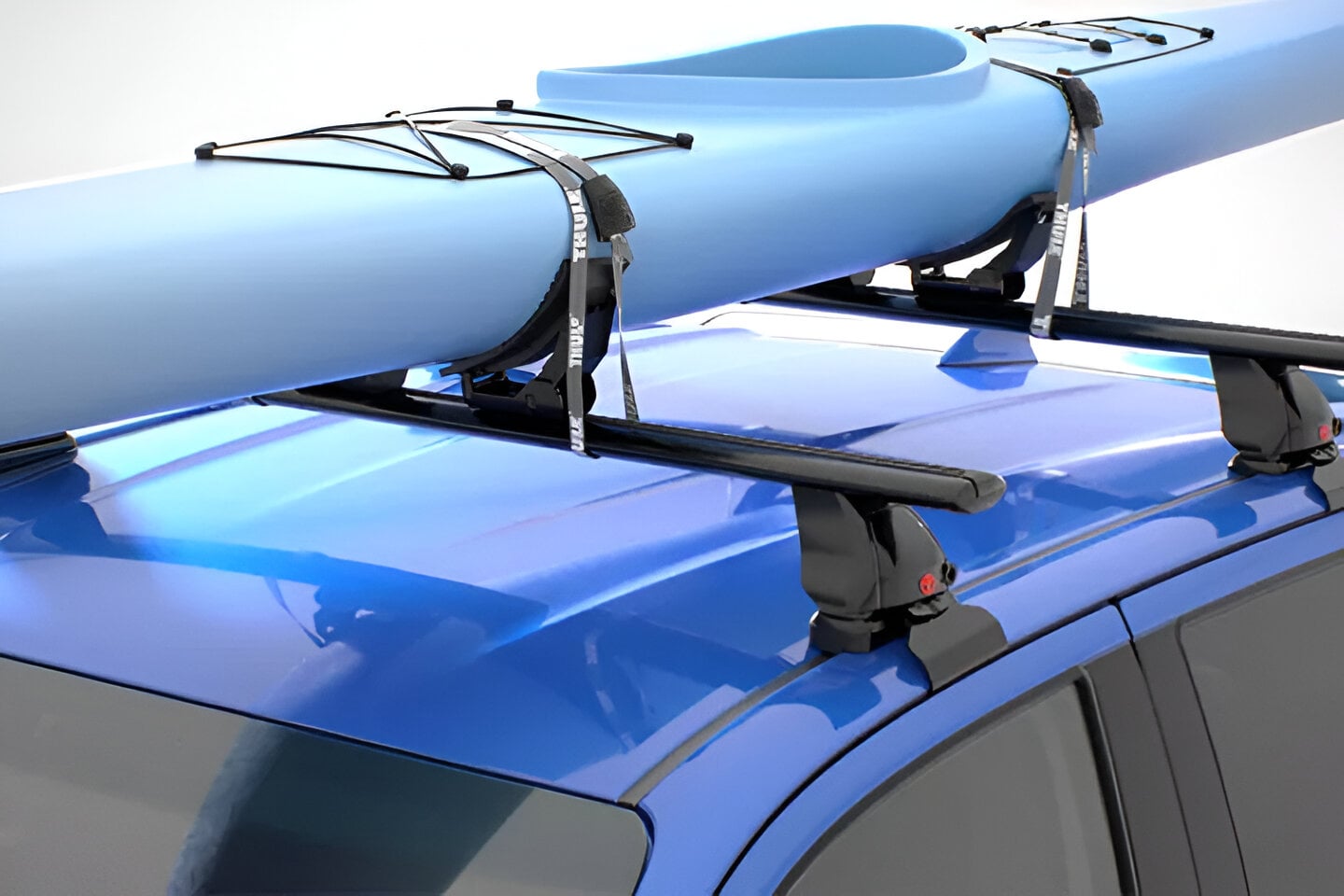 A blue kayak tied to a Toyota Genuine Roof Rack, on a blue Toyota 4x4
