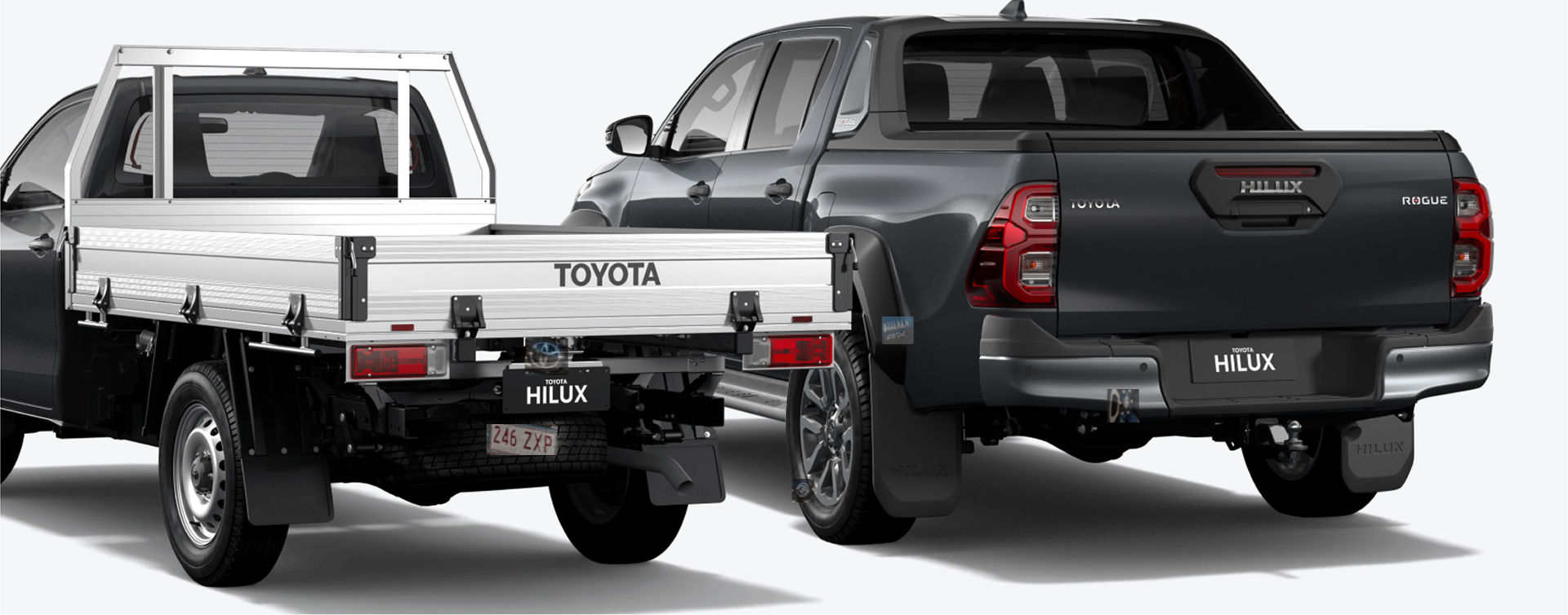 The rear view of two Black Toyota Hilux utes side by side. The left ute is a HiLux single-cab chassis with a Toyota Genuine Alloy Tray. The right ute is a HiLux double cab pick-up